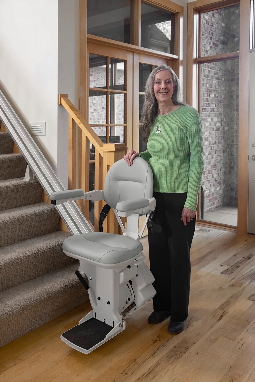 Woman standing beside stairlift in home